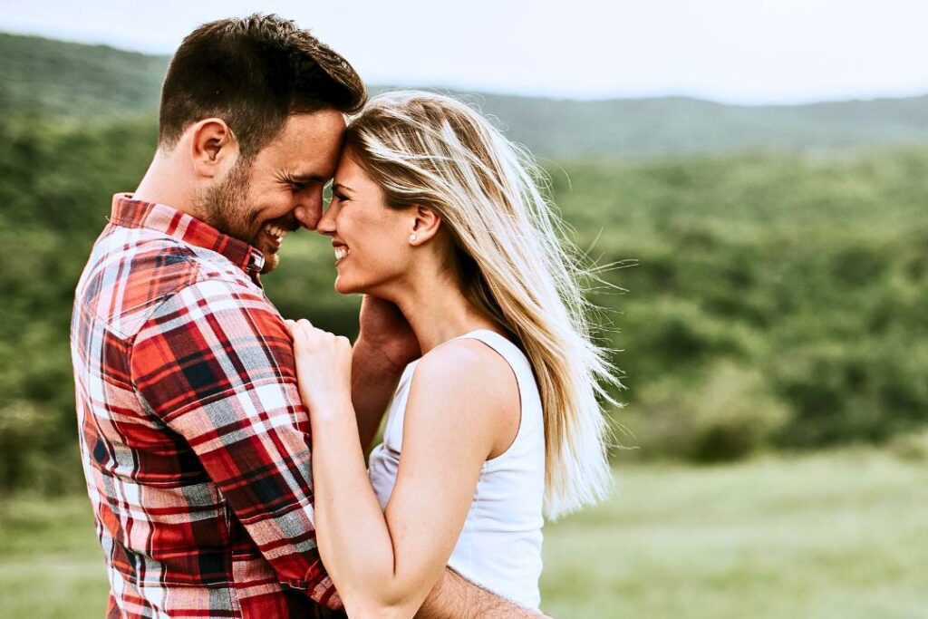 Happy couple embracing and smiling in a scenic outdoor setting, symbolizing the joy and connection achieved through effective marriage counseling at Directions Counseling & Coaching in Columbus, Ohio.